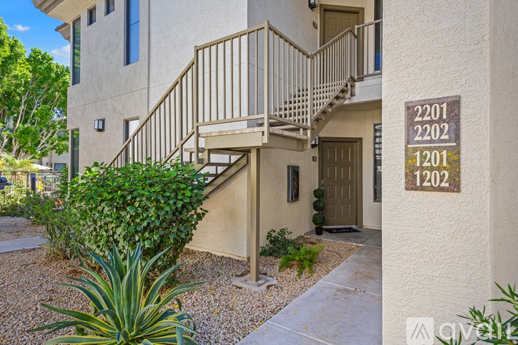 A room with wooden flooring and a window with white curtains.
