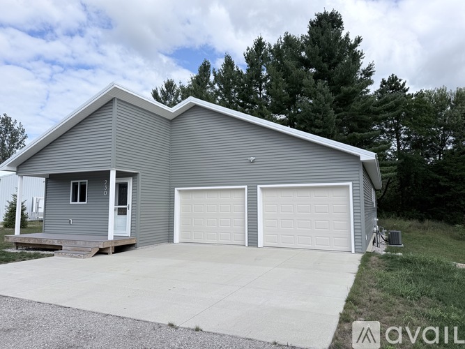 A two-car garage with a grey house in the background.