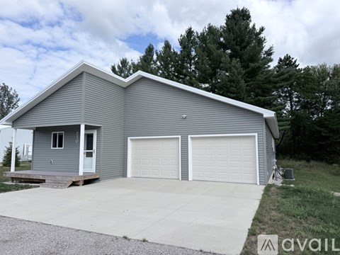 A two-car garage with a grey house in the background.