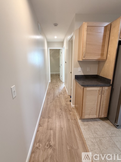 A kitchen with wooden cabinets and a black countertop.