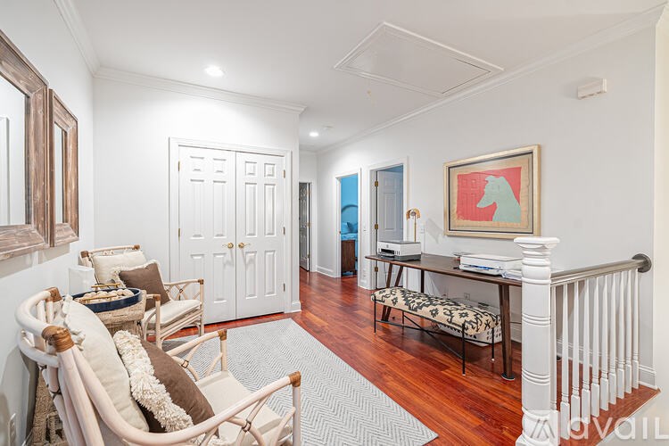 A living room with a white door and a painting on the wall.