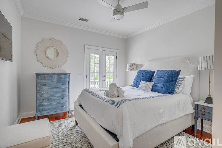A bedroom with a large bed and a blue dresser.