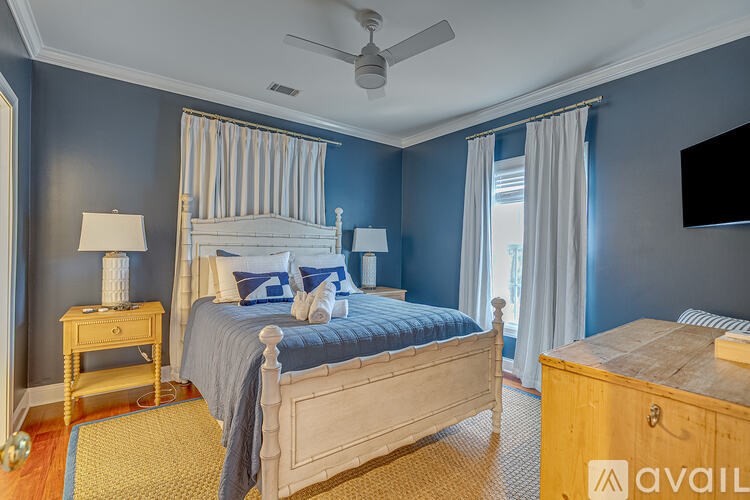 A bedroom with a bed, nightstand, and a ceiling fan.