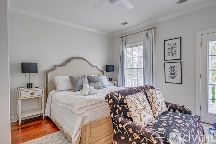 A bedroom with a large bed and a chair.