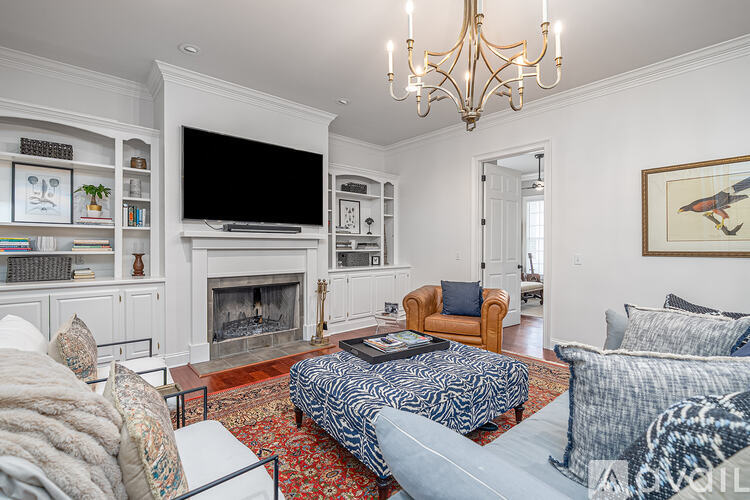 A living room with a fireplace and a television on the wall.