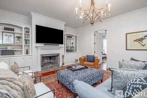 A living room with a fireplace and a television on the wall.