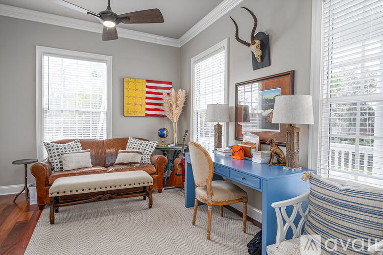 A room with a blue desk and a brown couch.