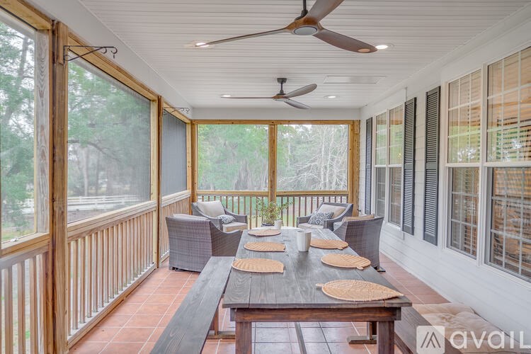 A sunroom with a table and chairs and a ceiling fan.