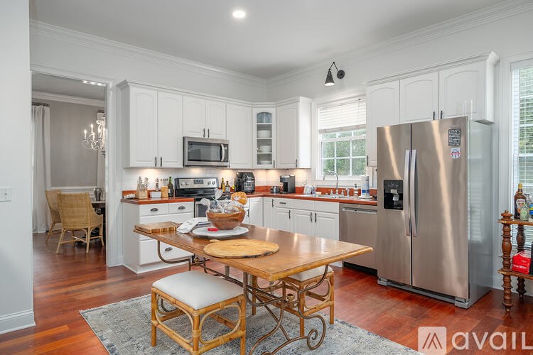 A kitchen with a wooden table and stainless steel appliances.