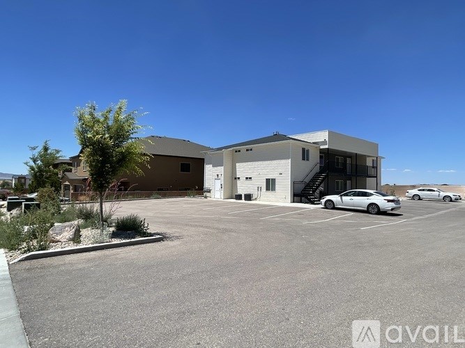 A parking lot with a building and a car in front.