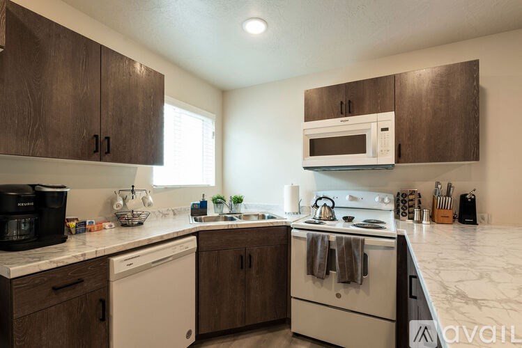 A kitchen with white appliances and wooden cabinets.