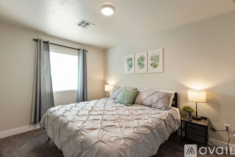 A bedroom with a large bed and two lamps.