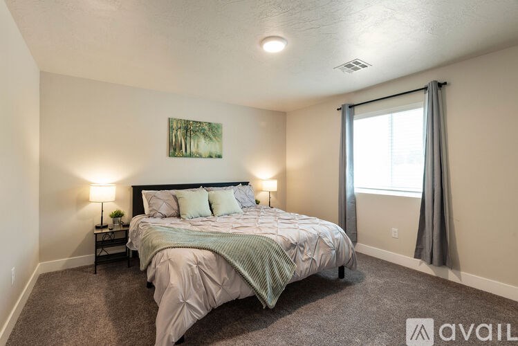 A bedroom with a large bed and a painting on the wall.