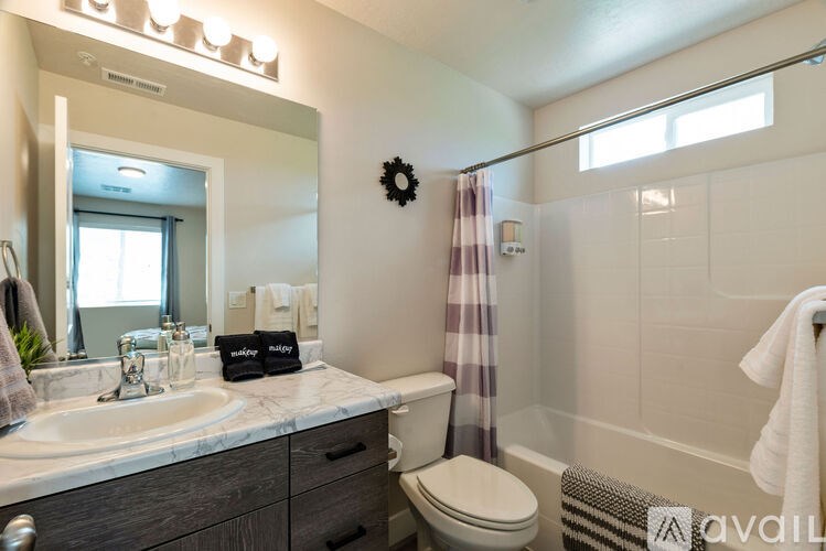 A bathroom with a toilet, sink, and mirror.
