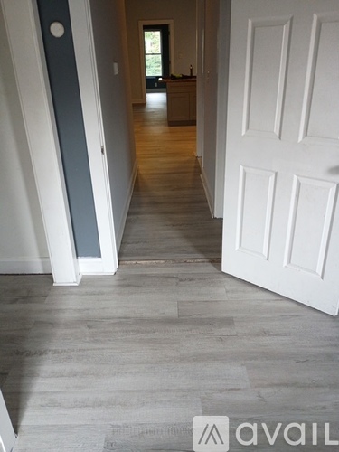 A hallway with a white door and a grey floor.