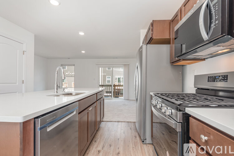 A modern kitchen with stainless steel appliances and wooden cabinets.