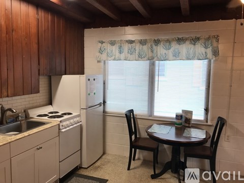 A kitchen with a table and chairs in front of a window.