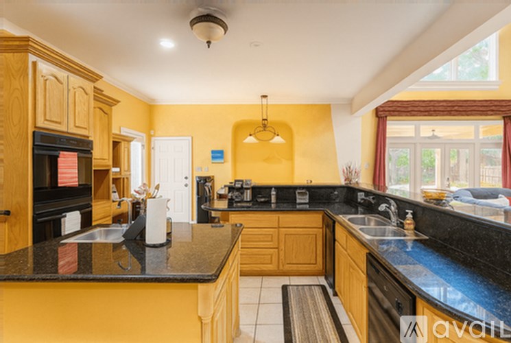 A kitchen with a black countertop and wooden cabinets.