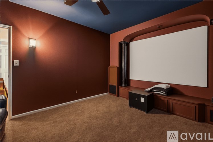 A home theater room with a large screen and a projector.