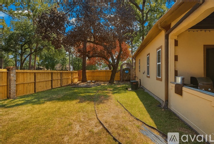 A house with a fence and a tree in front of it.