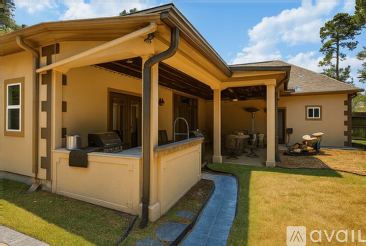 A house with a covered patio and a grill.