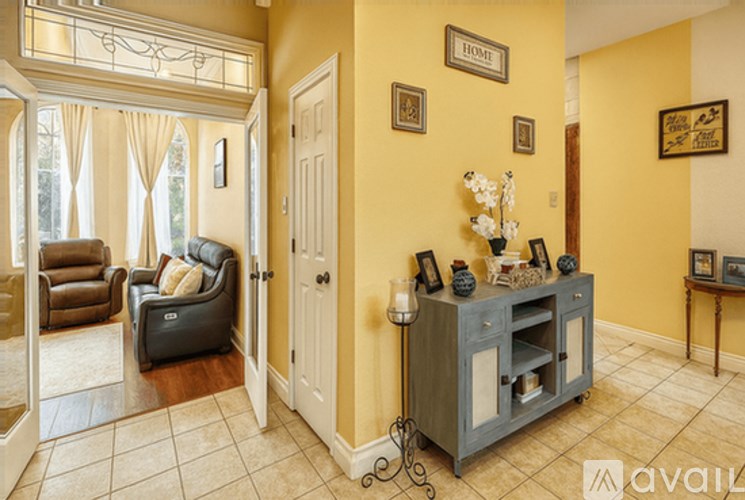 A living room with a brown chair and a grey cabinet.