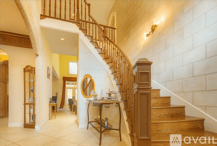 A staircase with a wooden banister and a mirror on the wall.