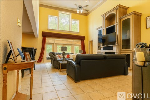A living room with a black couch and a wooden table.