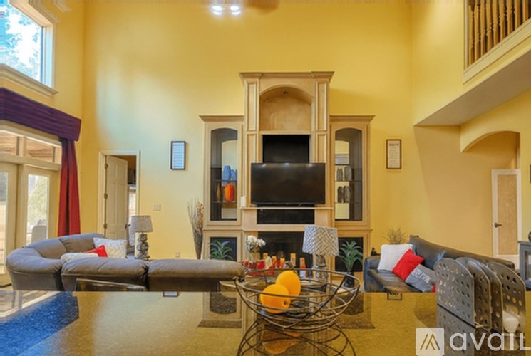 A living room with a sofa, a television, and a glass table.