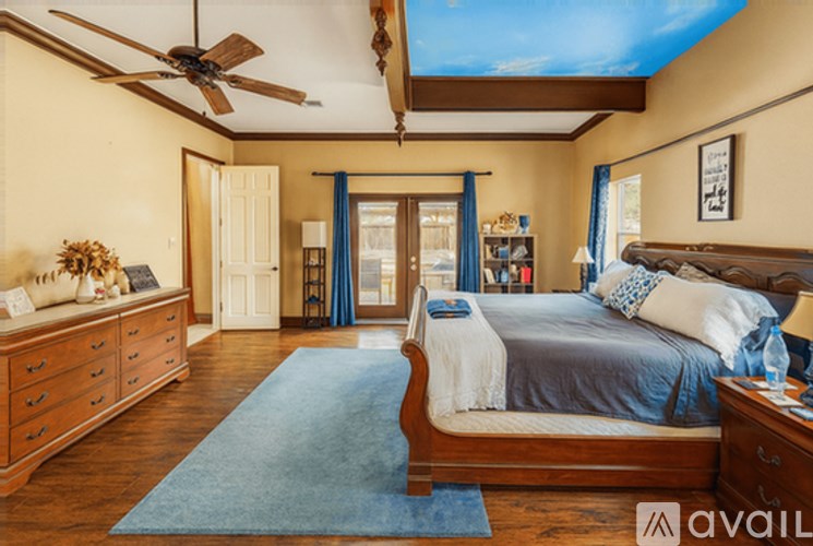 A bedroom with a bed, dresser, and ceiling fan.