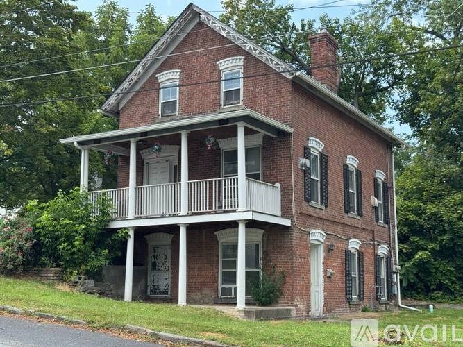 A red brick house with a white porch.