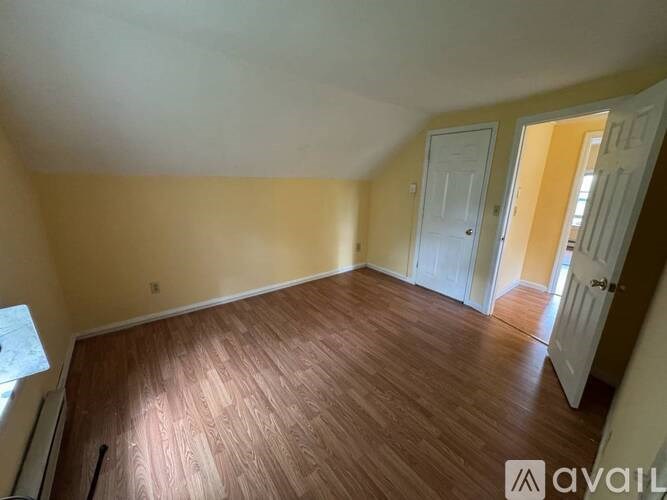 A room with wooden flooring and two doors.