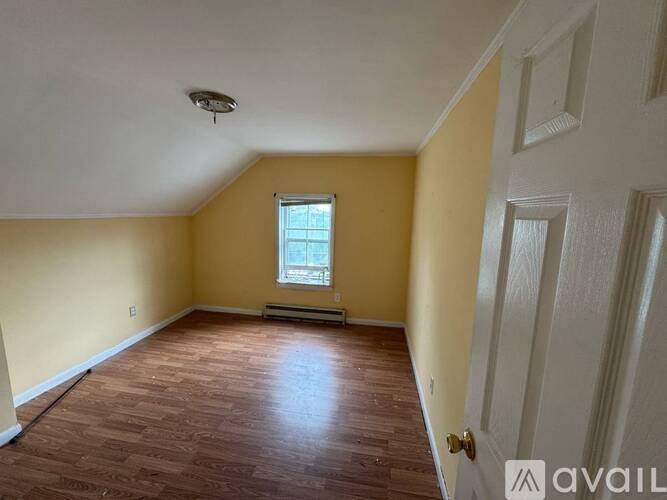 A room with wooden floors and a window.