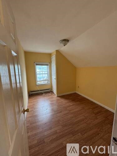 A room with wooden floors and a window.