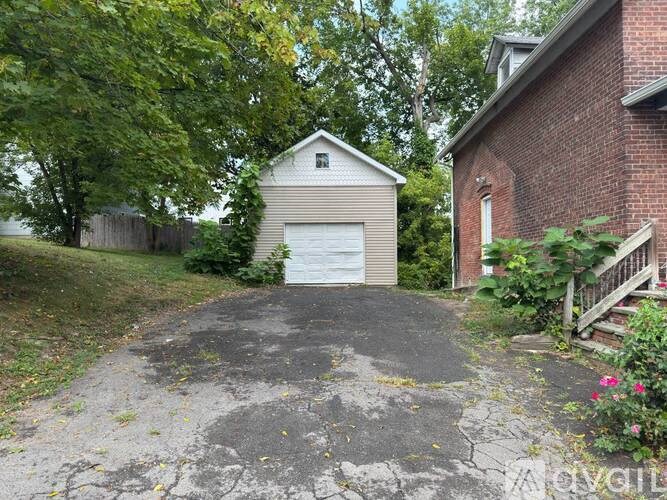 A driveway leads to a garage with a white door.