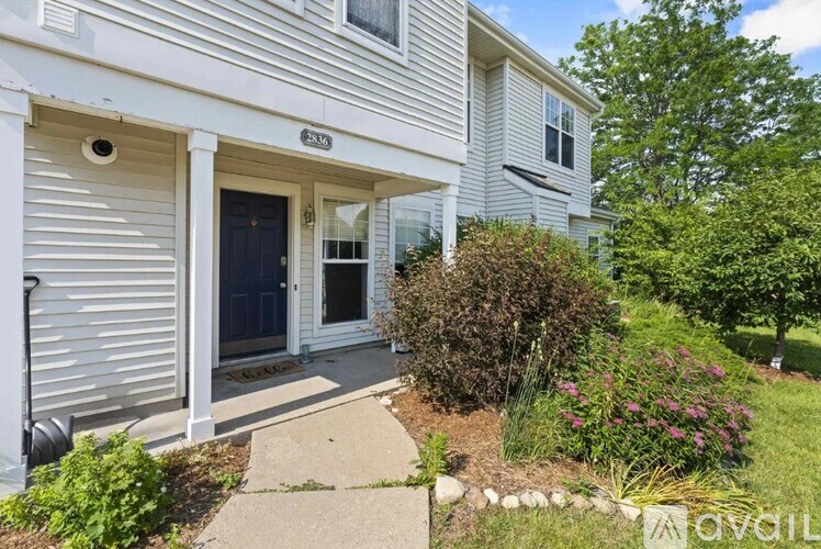A house with a white siding and a dark blue door is for sale.