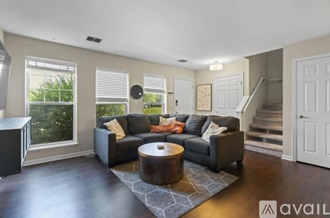 A living room with a black couch and a round coffee table.