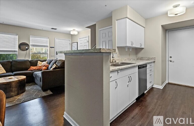A kitchen with white cabinets and a wooden floor.