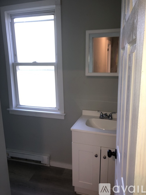 A bathroom with a sink and a window.
