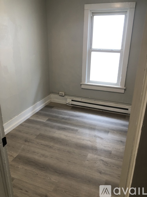 A room with a window and wooden flooring.