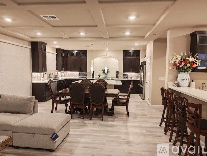 A modern kitchen with dark brown cabinets and a large island with a sink.