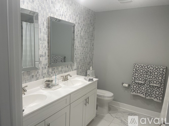 A bathroom with a white sink, toilet, and a mirror above the sink.