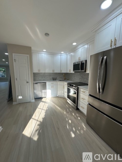A kitchen with a refrigerator, microwave, and oven.