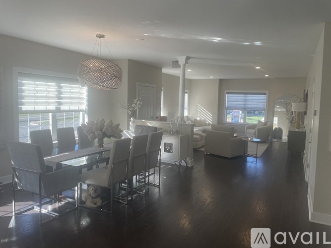 A spacious room with wooden flooring and a sliding glass door leading to a backyard.