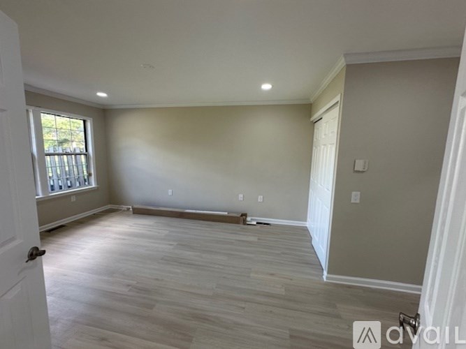 A room with light wooden flooring and white walls is available for rent.