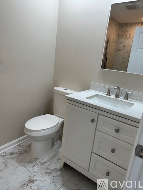 A white toilet sits next to a sink in a bathroom.