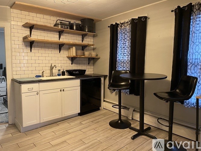 A kitchen with black chairs and a black oven.