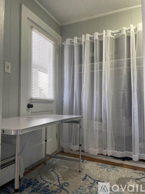 A white table with a curtain behind it.