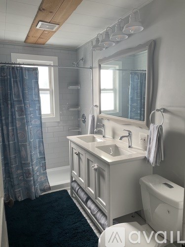 A bathroom with a sink, mirror, toilet and shower.