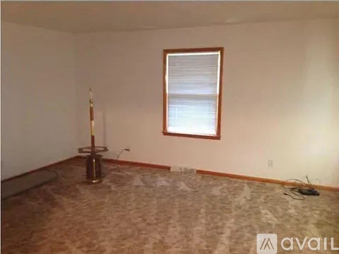 A room with a window and a floor heater.